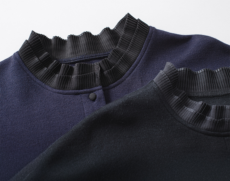 プリーツ加工の黒い襟とボタンディテールのアップ画像（ネイビーのカーディガン）