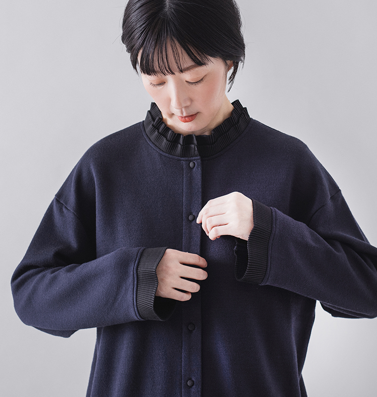 ネイビーのボタンアップカーディガンを着用した正面上半身のイメージ（黒のプリーツ襟とプリーツ袖）