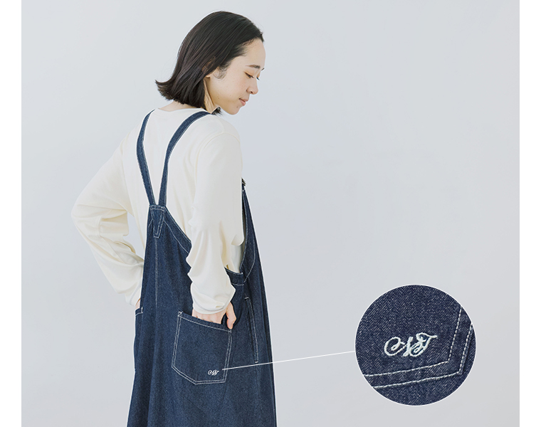 ワークジャンパースカートを着用し背中側の肩ひもとポケットが見える後ろ姿