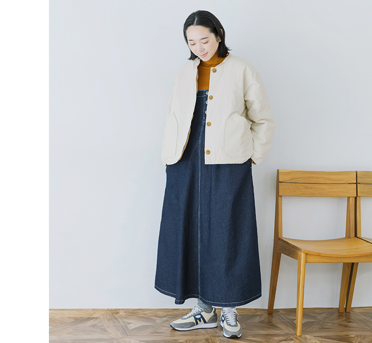 ワークジャンパースカートにアウターを重ねて立つ全身正面