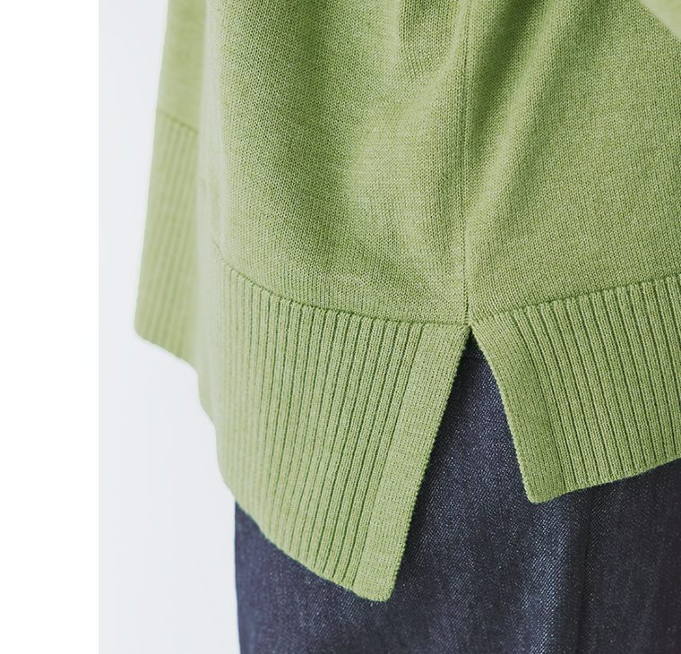 グリーンのカーディガンの裾とサイドスリットの寄りカット