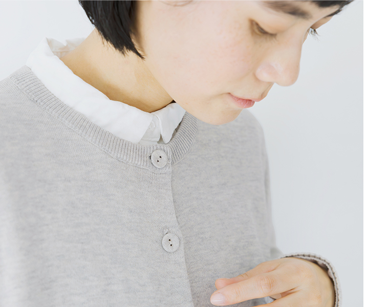 ライトグレーのカーディガンの胸元とボタンのディテール