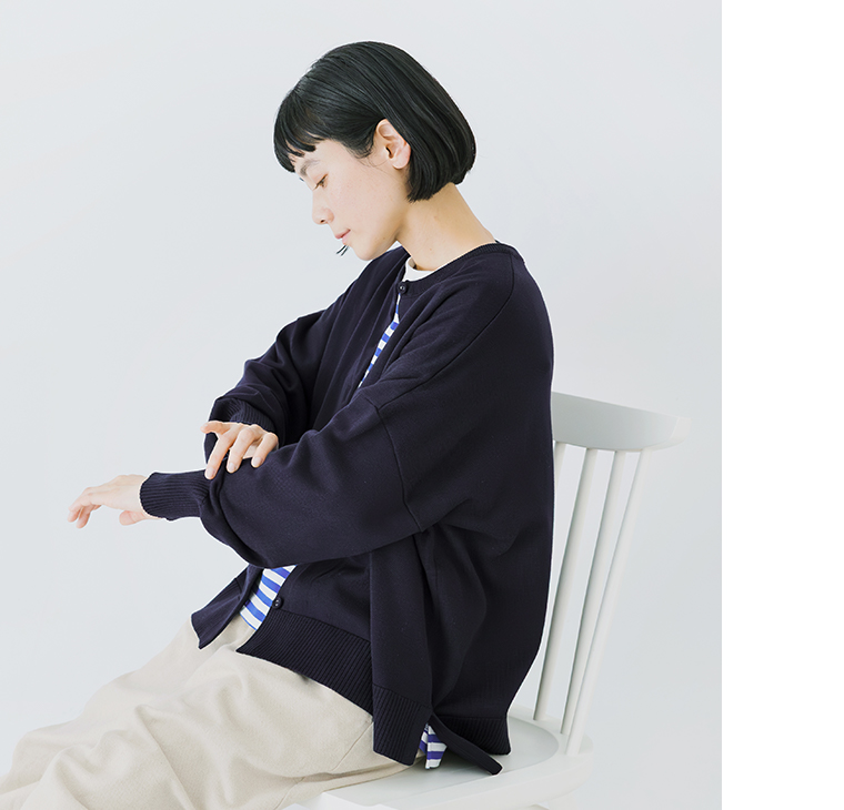 ネイビーのカーディガンをボーダーシャツとパンツに合わせた着席コーディネート