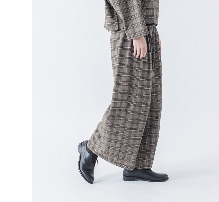 チェックのショートテーラードジャケットとタックワイドパンツを着た歩き姿のコーディネート下半身寄り