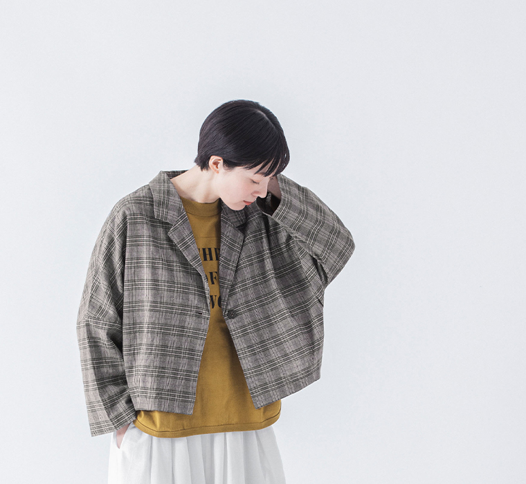 チェックのショートテーラードジャケットを着た上半身のコーディネート