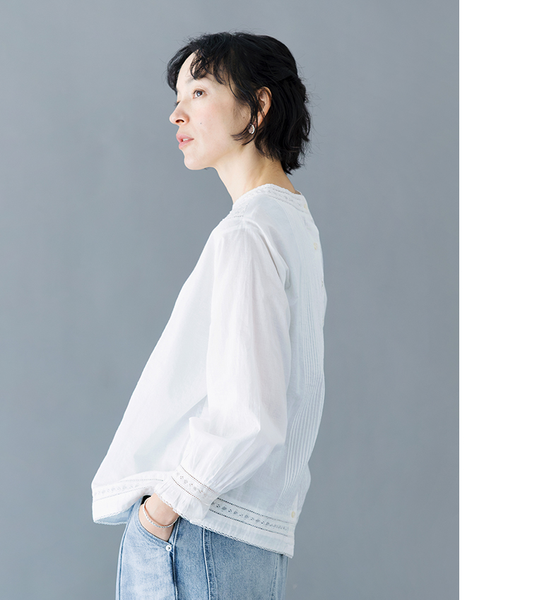 ホワイトの長袖ブラウスを着用した横向きスタイル（ピンタックとレースディテール）