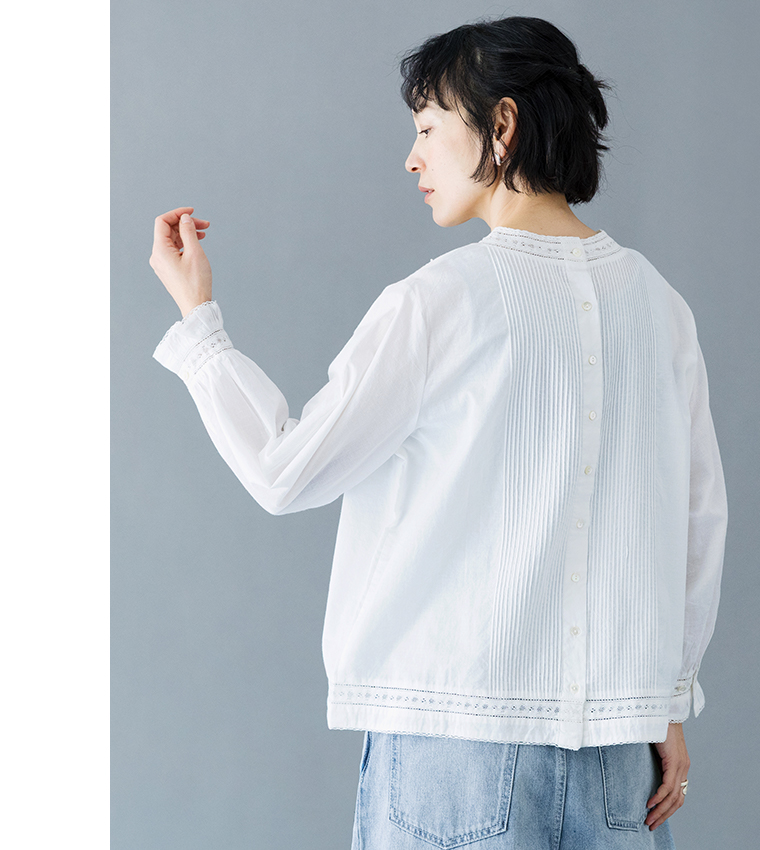 ホワイトの長袖ブラウスのバックスタイル（ピンタックとボタン、レースディテール）