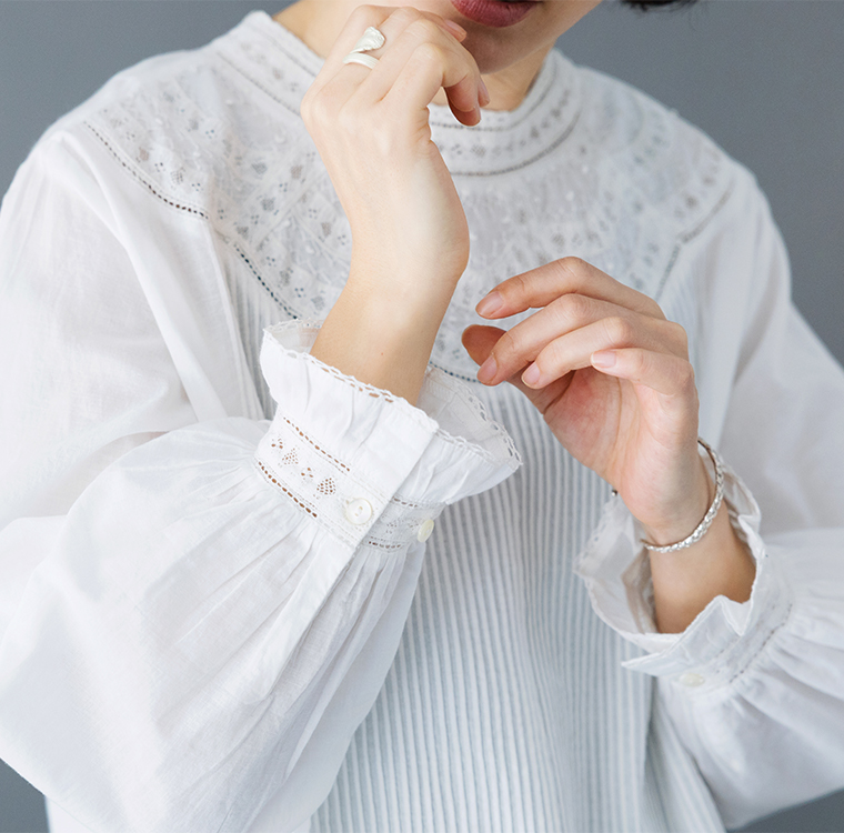 ホワイトブラウスの袖口と首元のレース・刺しゅうディテール（アクセサリー付き）