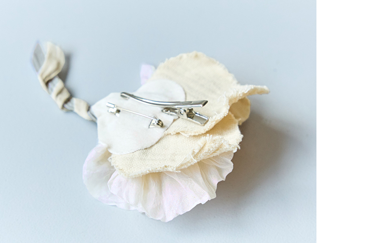 布花コサージュの裏側に付いたクリップとピン金具を写したディテール画像