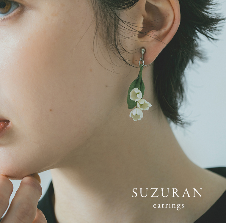 白いすずらんイヤリングを身につけた耳元のディテールカット