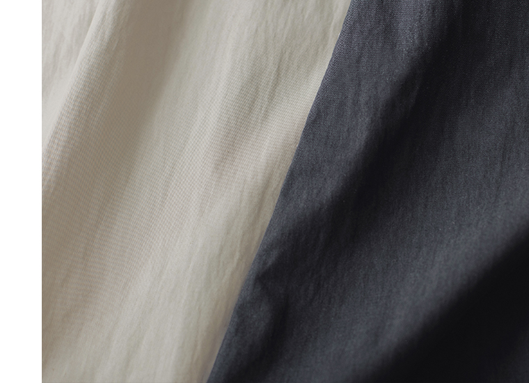 コットンナイロン ダブルボタンジャケットのライトベージュとブラックの生地表面を寄りで写したカット