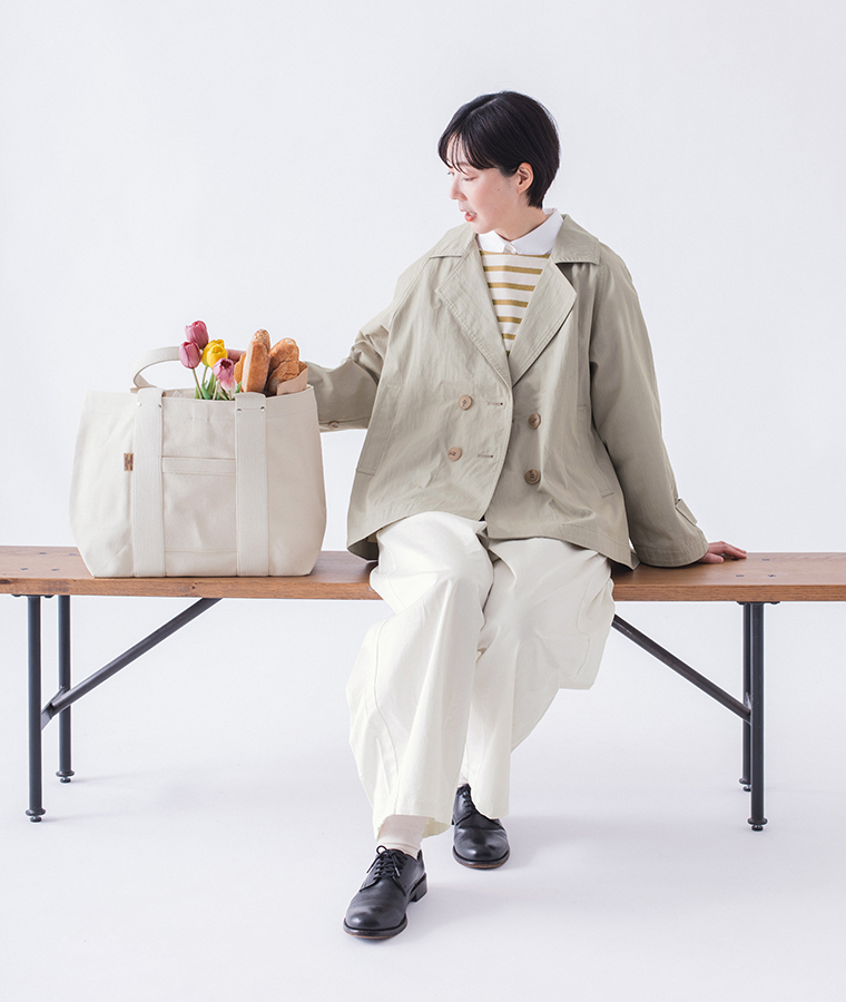 コットンナイロン ダブルボタンジャケット ライトベージュを着用しベンチに座ったパンツスタイルのコーディネートカット