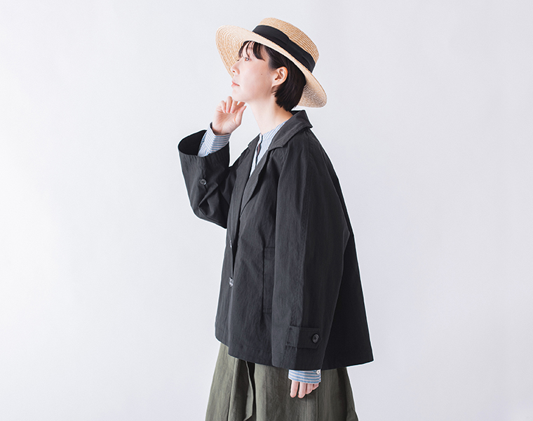 コットンナイロン ダブルボタンジャケットのブラックをストライプ柄トップスとスカートに合わせた横向きのコーディネートカット