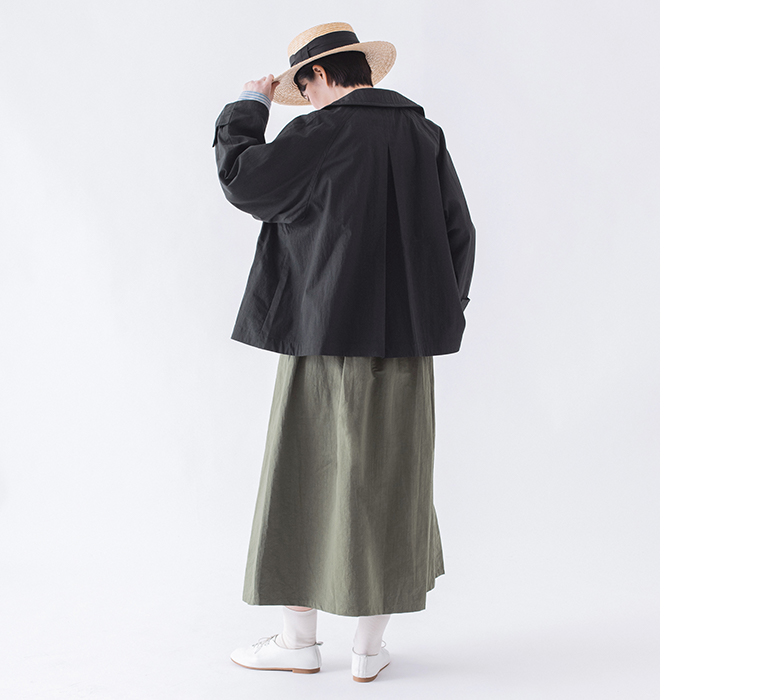 コットンナイロン ダブルボタンジャケットのブラックをストライプ柄トップスとスカートに合わせた後ろ姿のコーディネートカット