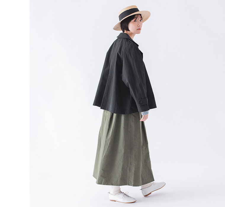 コットンナイロン ダブルボタンジャケットのブラックをストライプ柄トップスとスカートに合わせた振り返りのコーディネートカット