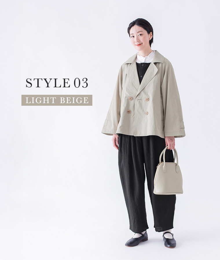 コットンナイロン ダブルボタンジャケット ライトベージュを着用しバッグを持った正面全身コーディネートカット