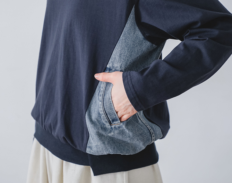 デニム切替プルオーバーの脇に配したデニム素材の切替ポケット部分を手を入れて見せたディテールカット