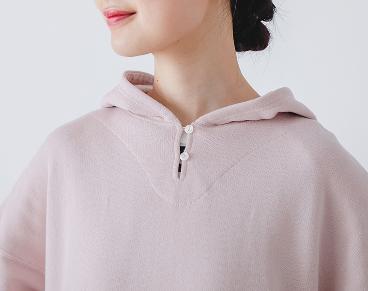 コットンガーゼ裏毛ドロストフーディのフード部分と前立てのボタン仕様をアップで写したカット