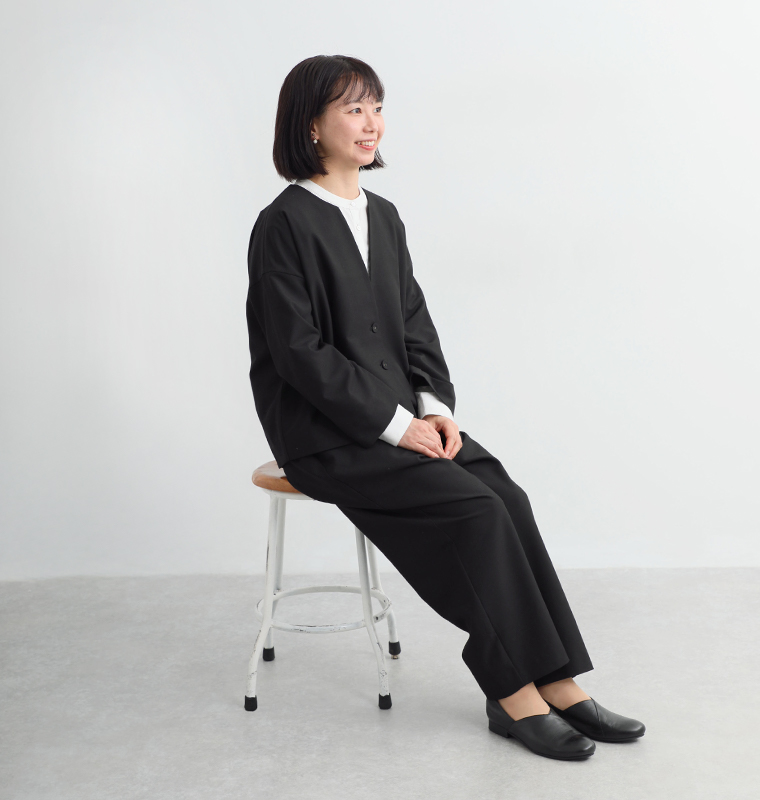 頼れる万能セットアップを身長158cmのスタッフが着用し椅子に座ったカット