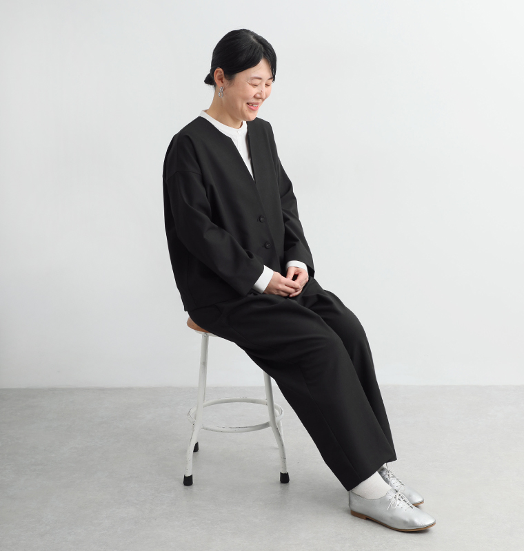 頼れる万能セットアップを身長162cmのスタッフが着用し椅子に座ったカット