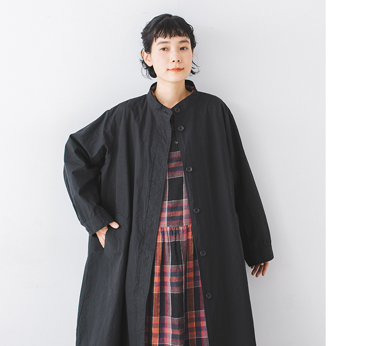 別注｜ハイネック比翼ミドル丈コートのブラックを前開きで着用し中にチェック柄ワンピースを合わせたカット