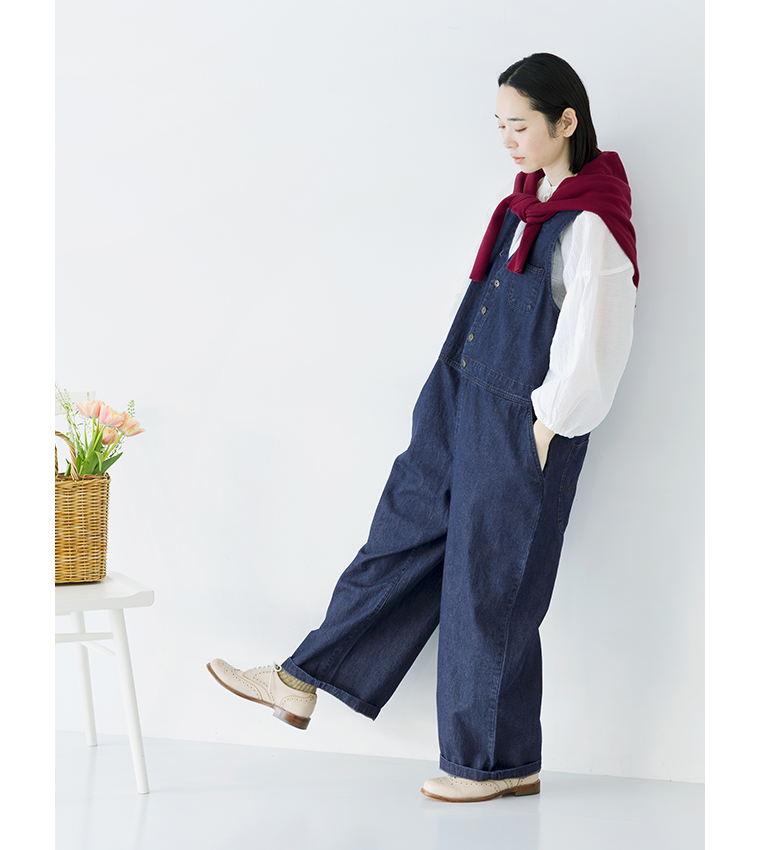 デニムサロペット(ネイビー)の赤いカーディガンを肩掛けした横向き全身コーディネート