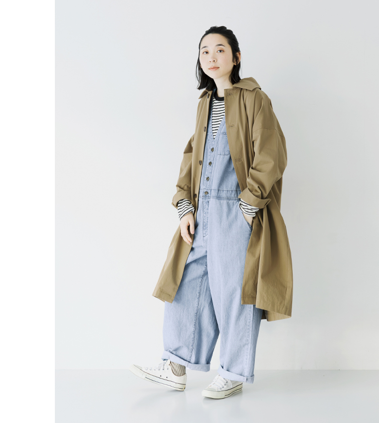デニムサロペット(ブルー)のベージュのコートを合わせた横向き全身コーディネート
