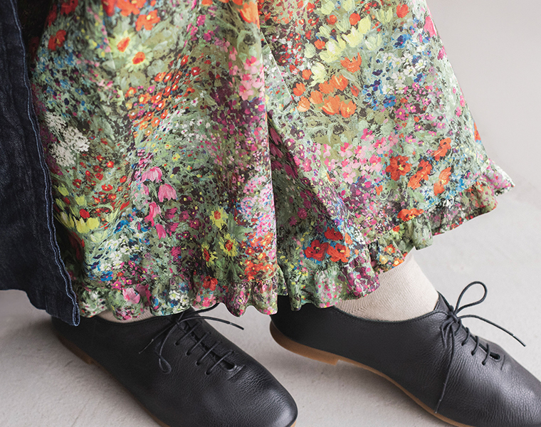 カラフルなフラワープリントパンツの裾と足元のコーディネート（クリーム色のソックスと黒のレースアップシューズを合わせたスタイリング）