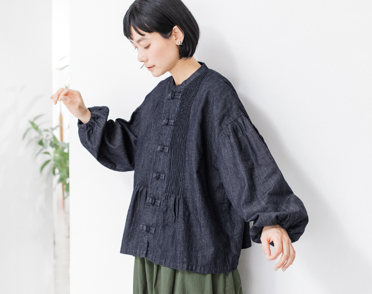 コットンリネンデニム チャイナボタンブラウスを着用した女性モデルの斜めスタイル