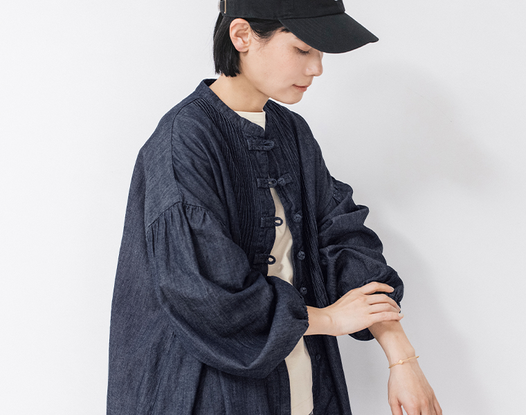 コットンリネンデニム チャイナボタンワンピースを羽織った女性モデルの上半身スタイル