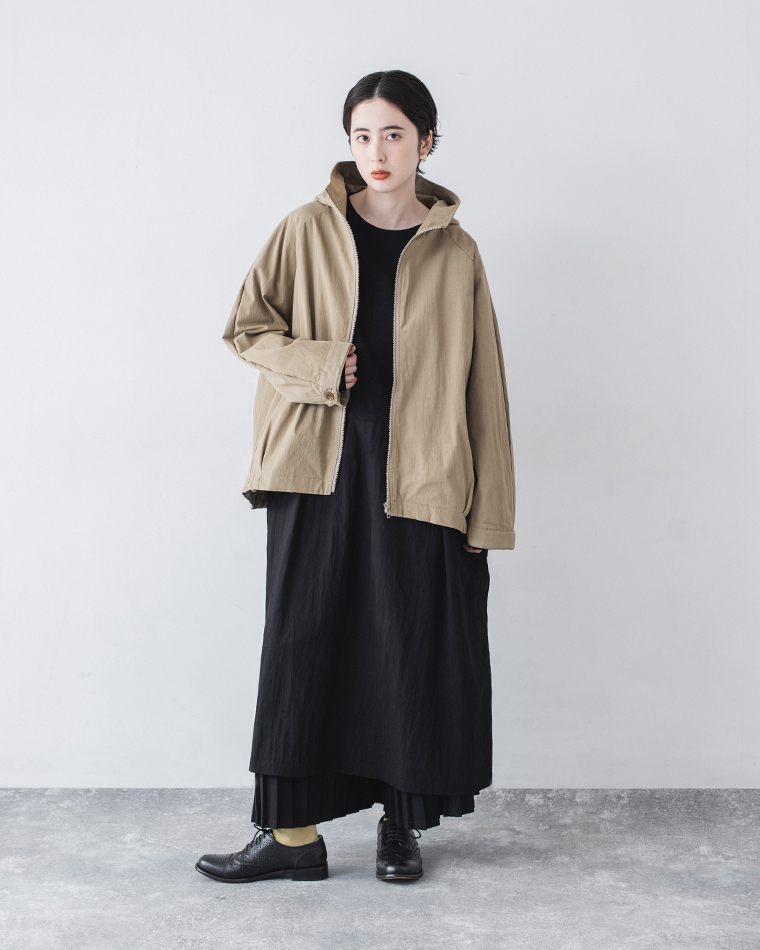 グレイベージュのフード付きジップジャケットを着用した正面コーディネート（無地背景）