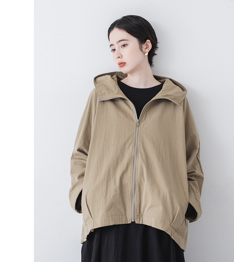 グレイベージュのフード付きジップジャケットを黒のワンピースに重ねた正面スタイリング