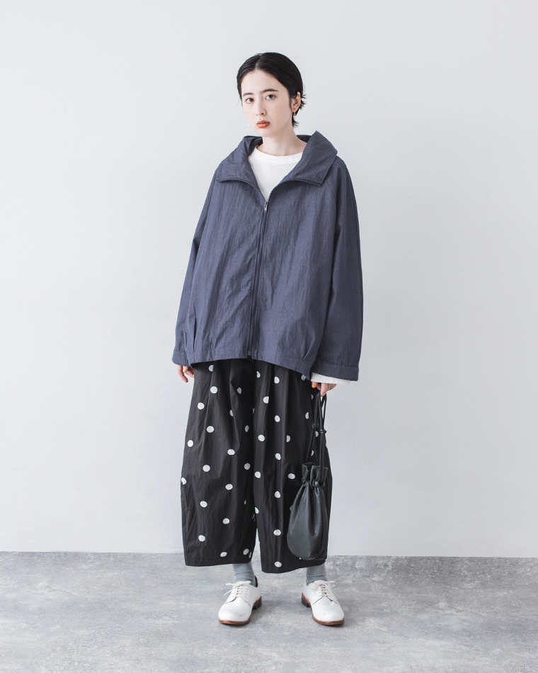 ネイビーのジップジャケットを白トップスとドット柄ワイドパンツに合わせたカジュアルコーディネート（手提げバッグ付き）