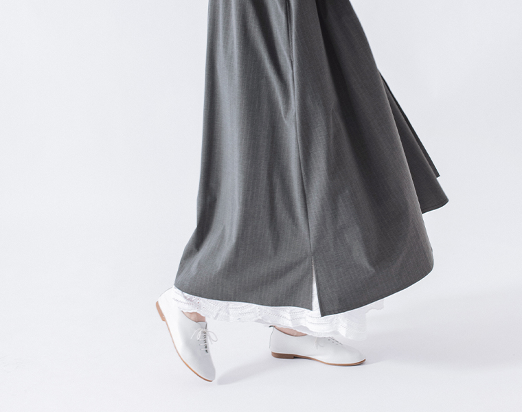 バンドカラーストライプワンピース（グレー）着用の白パンツを合わせた裾寄りの動きのあるカット