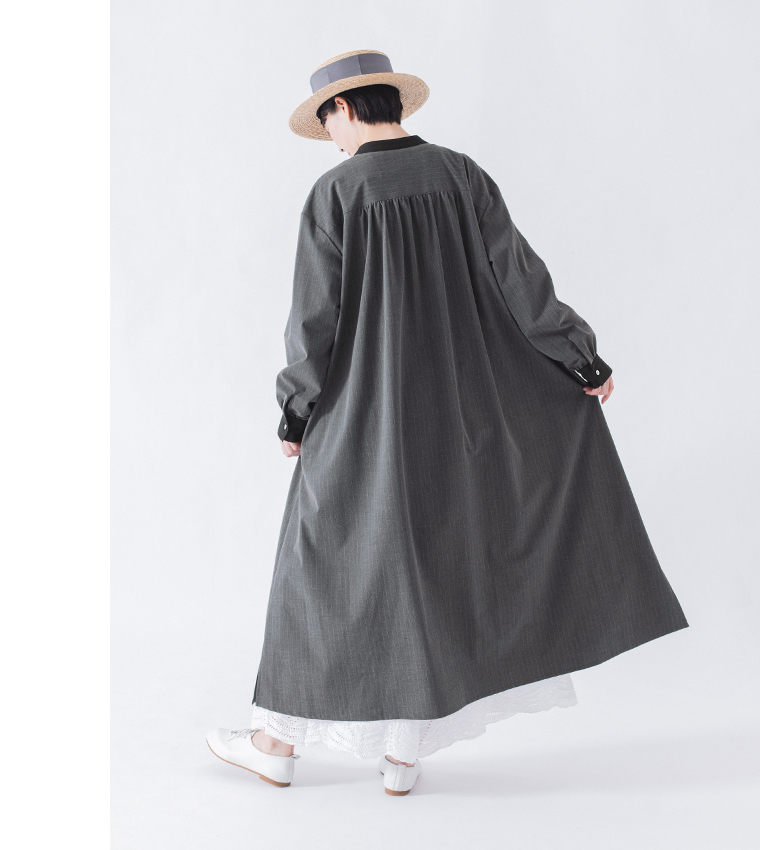 バンドカラーストライプワンピース（グレー）着用の白パンツを合わせた動きのある全身バックスタイルのコーディネート