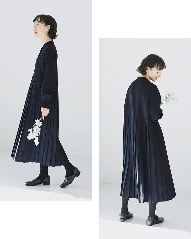 ネイビーのプリーツワンピースを着用した正面コーディネート（白い花束を手に持つ）