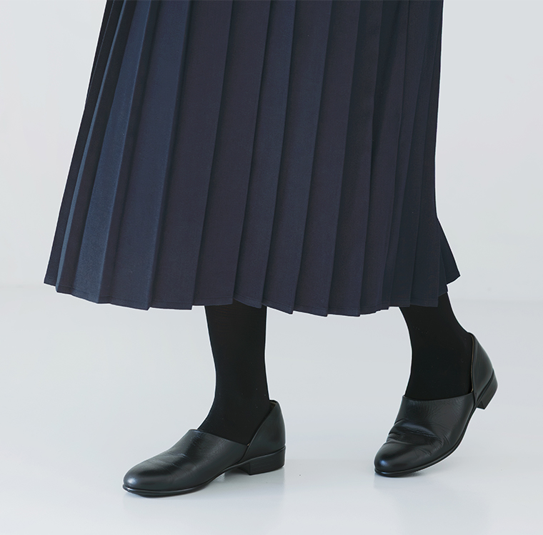 ネイビーのプリーツワンピースに黒タイツとレザーシューズを合わせた足元コーディネート