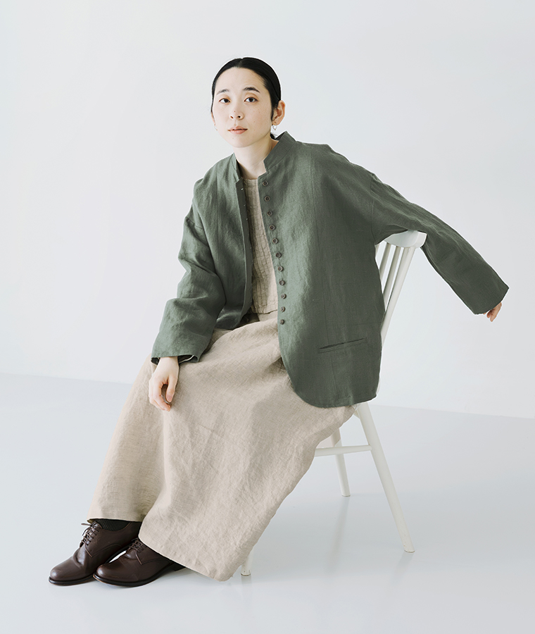 別注｜9番手リネン 多ボタンジャケット モスグリーンを着用したモデルが椅子に座っている全身カット
