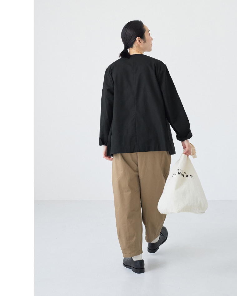 alt: ブラックのジャケットとベージュパンツを合わせたカジュアルな後ろ姿コーディネート