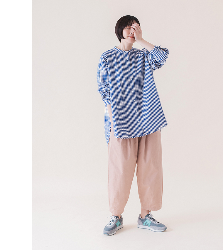 ギンガムチェックバンドカラーシャツ(ブルー)着用のパンツのポケットに手を入れた全身コーディネート