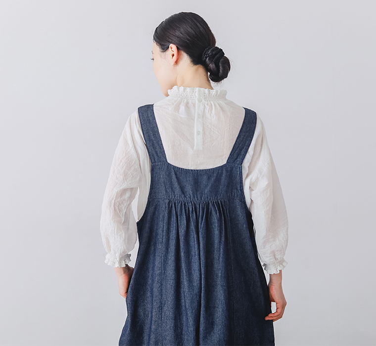 デニムフロントタックサロペットを着用したモデルの後ろ姿上半身カット