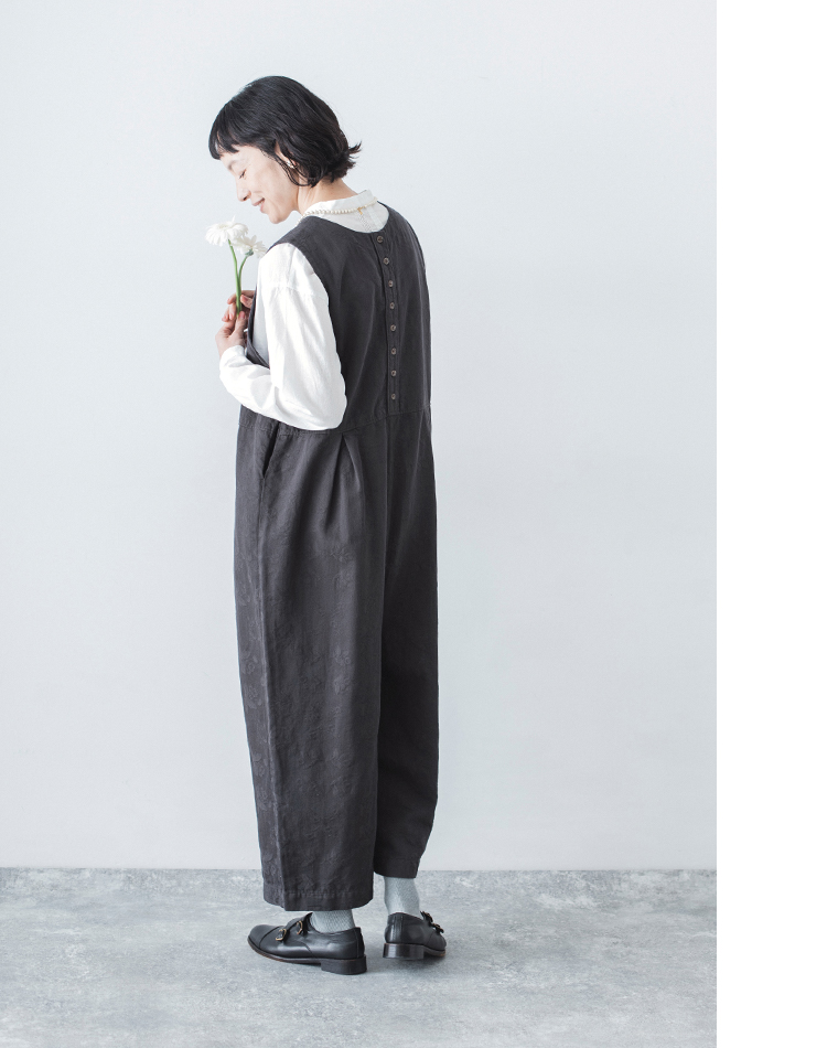 チャコールの2wayオールインワンを白ブラウスに重ねた後ろ姿のコーディネート画像