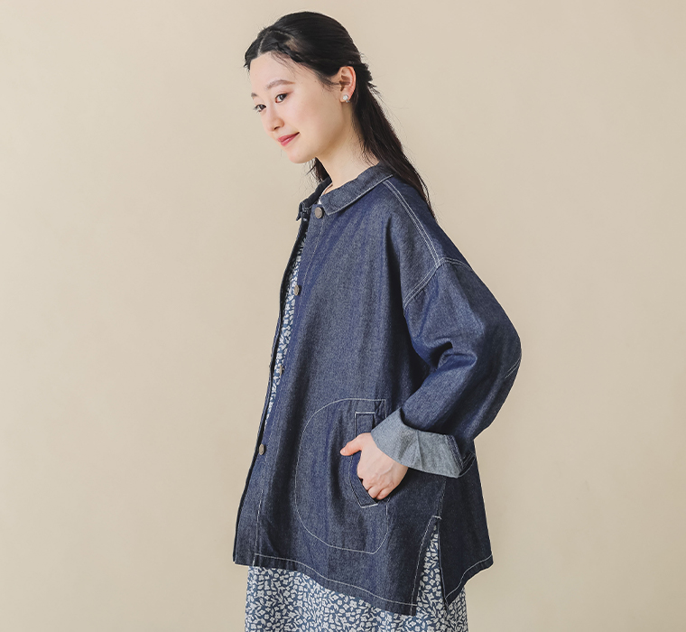 キャンブリックプリントワンピースを着用したモデルのジャケットを羽織った横向き上半身カット