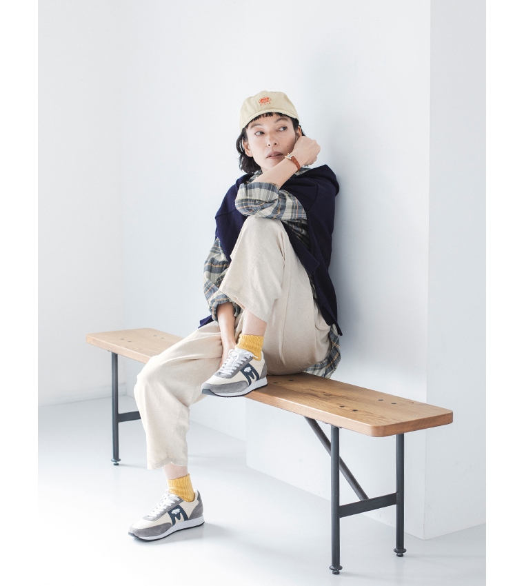 ベイカーパンツ(キナリ)を着用し椅子に座った全身カット