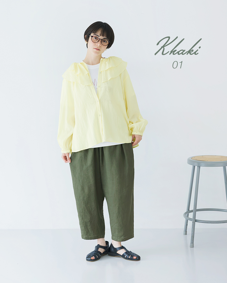 ライトイエローの長袖トップスにカーキのパンツを合わせ、黒のサンダルでまとめた全身コーディネート画像