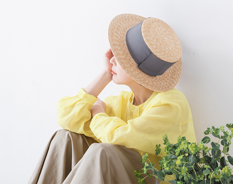シアーリネンバンドカラーブラウス(イエロー)着用の座って上半身に寄ったカット