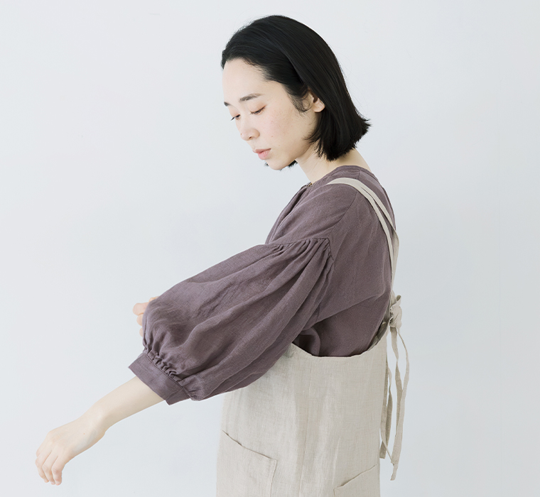 多ボタンブラウス(パープル)を着用しバルーン袖を見せる横カット