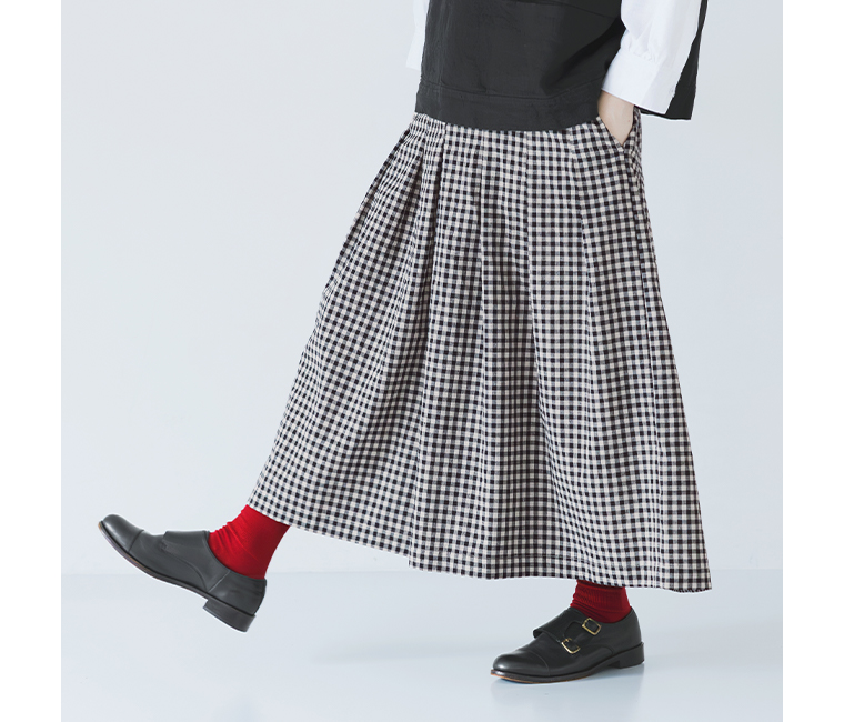 ヴィンテージライクギンガムチェックワイドパンツのブラックを着用した女性モデルの足さばきがわかるサイドスタイル