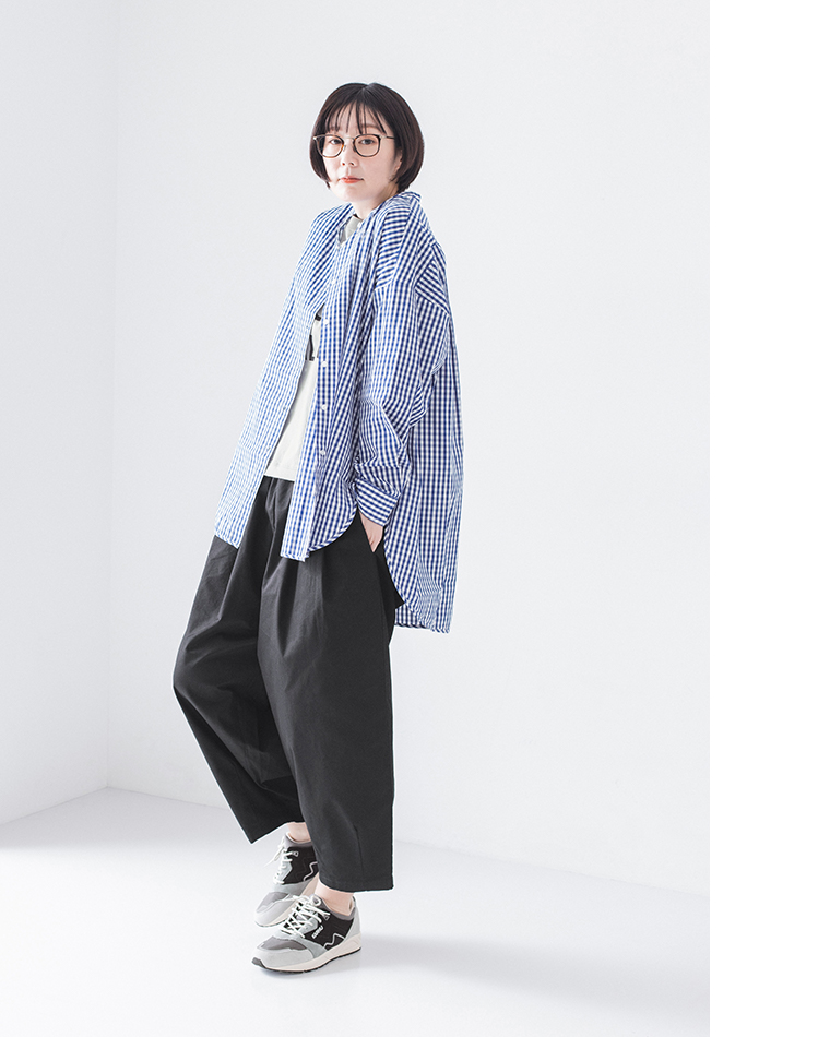 チェックシャツを羽織り、白トップスにブラックのチノパンツとスニーカーを合わせた正面コーディネート