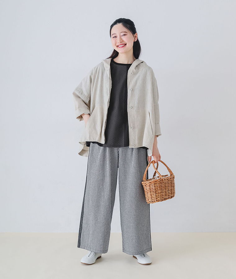 モデルがコットンリネン サイドレースセミフレアパンツを着てかごバッグを持った全身正面カット